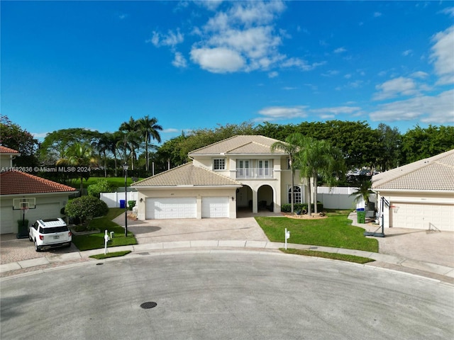 mediterranean / spanish house with a garage, a balcony, and a front yard