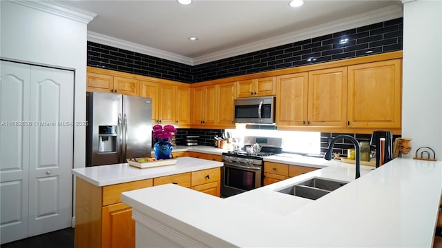 kitchen featuring crown molding, stainless steel appliances, a sink, a kitchen island, and a peninsula