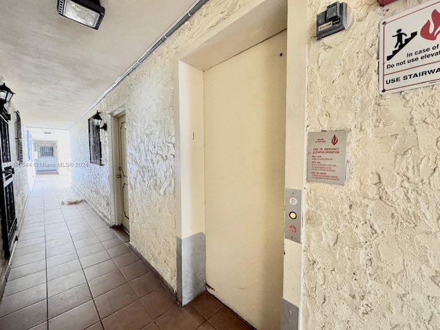 hall featuring elevator and tile patterned floors