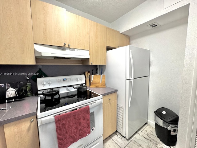 kitchen featuring a textured ceiling, light brown cabinets, and white appliances