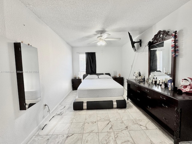 bedroom with ceiling fan and a textured ceiling