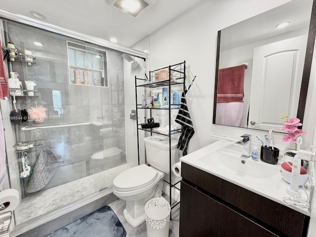 bathroom featuring vanity, toilet, and a shower with door