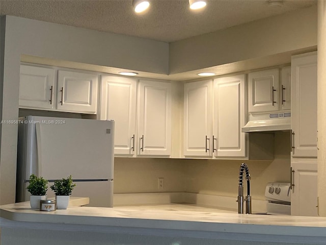 kitchen featuring a textured ceiling, white appliances, white cabinetry, and extractor fan