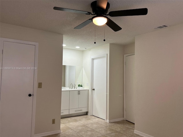 bathroom featuring tile patterned floors, ceiling fan, vanity, and a textured ceiling