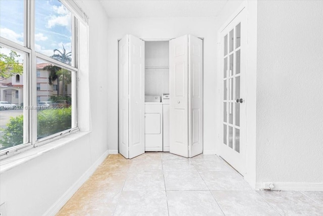 interior space featuring multiple windows, washer and clothes dryer, and baseboards