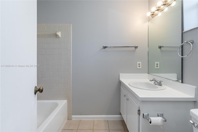 full bathroom featuring tiled shower / bath, tile patterned flooring, vanity, and toilet