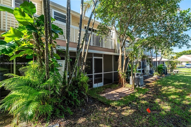 rear view of house featuring a yard and central AC