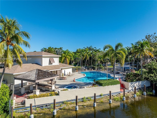 view of pool with a gazebo, a patio, and a water view