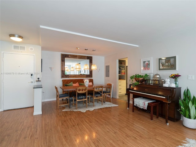 dining space with light wood-type flooring and electric panel