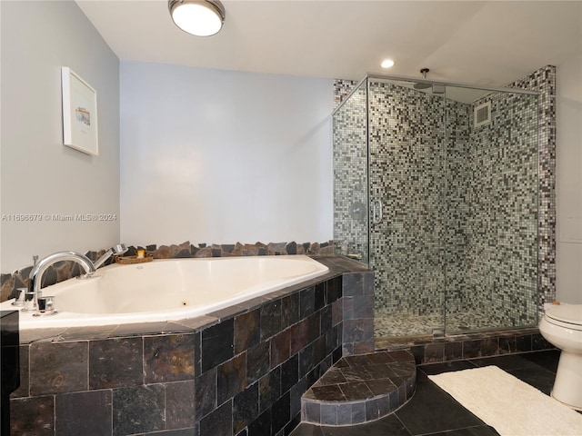 bathroom featuring plus walk in shower, tile patterned floors, and toilet