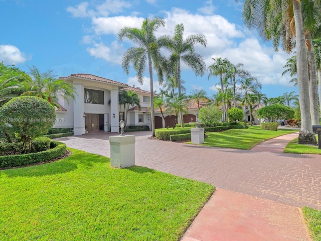 view of community with decorative driveway and a lawn