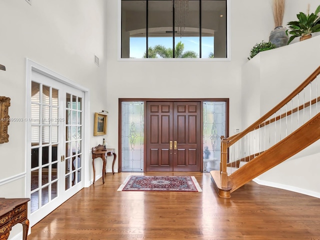 foyer entrance featuring hardwood / wood-style flooring and a high ceiling