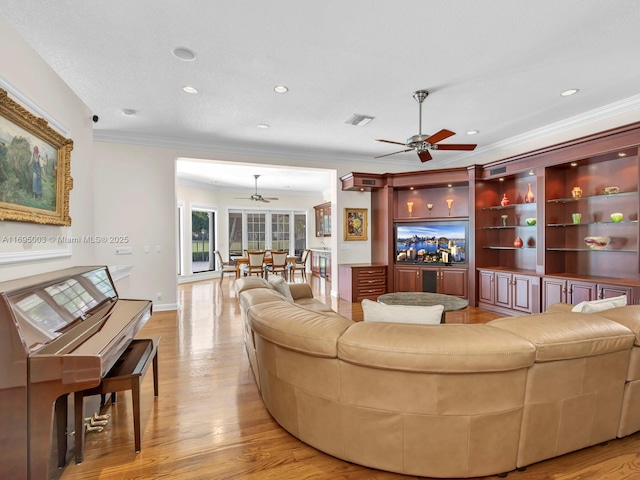 living room featuring ceiling fan and crown molding