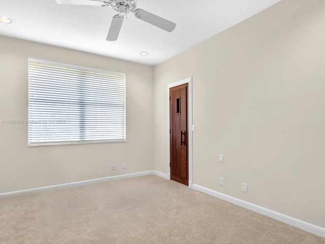 unfurnished room with ceiling fan and light carpet