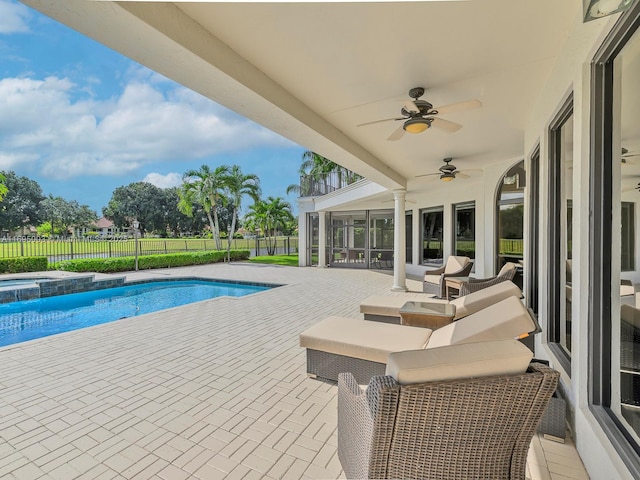 view of swimming pool with a sunroom, ceiling fan, a patio area, and an in ground hot tub