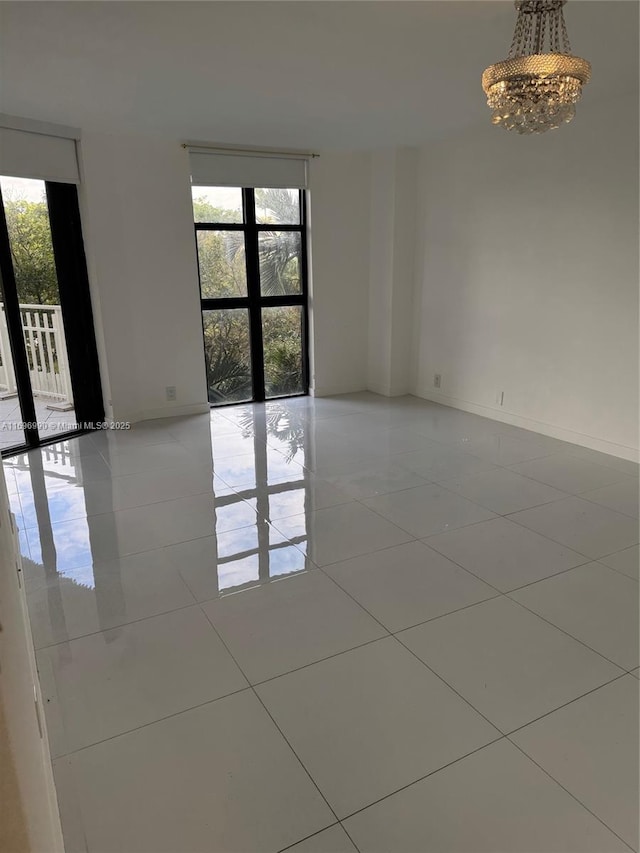 spare room featuring light tile patterned floors and a notable chandelier