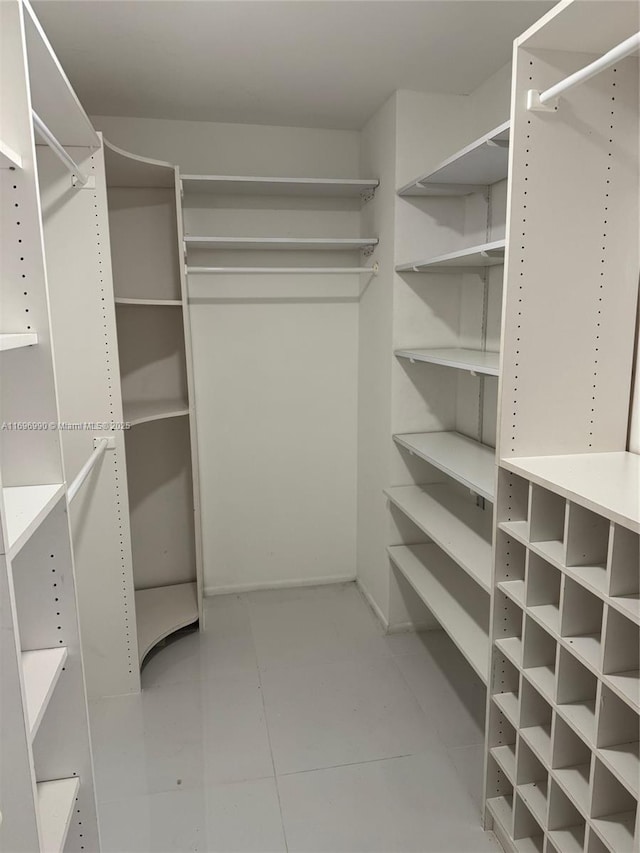 walk in closet with light tile patterned floors