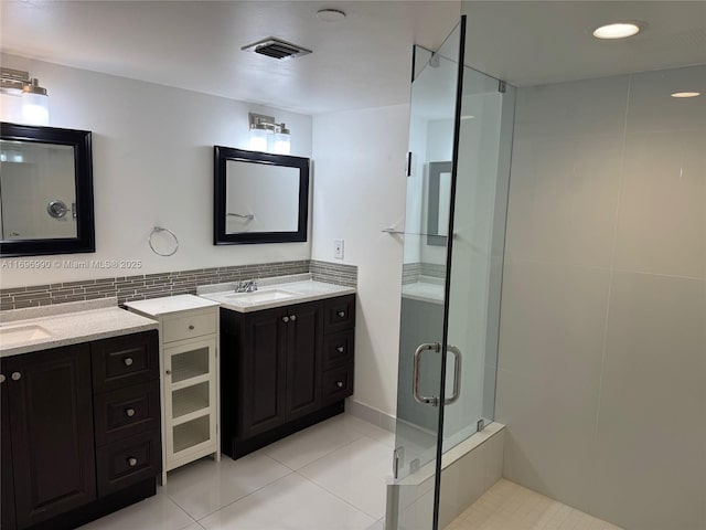 bathroom with backsplash, tile patterned floors, a shower with door, and vanity