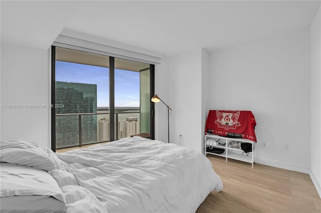 bedroom featuring a wall of windows and hardwood / wood-style flooring