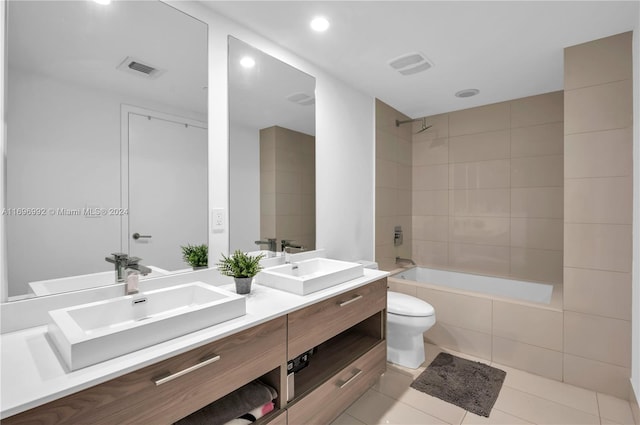 full bathroom featuring toilet, vanity, tiled shower / bath combo, and tile patterned floors