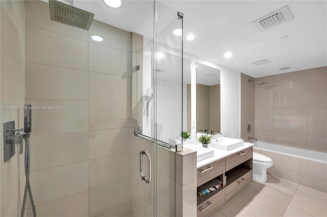 bathroom with tile patterned flooring, vanity, toilet, and a shower with shower door