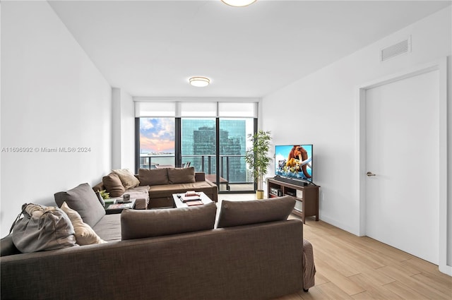 living room with light hardwood / wood-style floors and a wall of windows