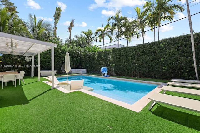 view of swimming pool with a lawn and a pergola