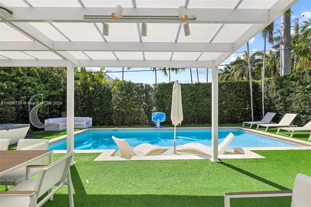 view of swimming pool with ceiling fan, a yard, and an outdoor living space