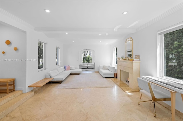 living room featuring beam ceiling, a premium fireplace, and crown molding