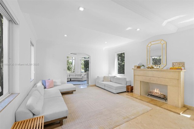 tiled living room with ornamental molding and a fireplace