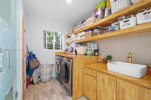 laundry room featuring washing machine and clothes dryer and sink