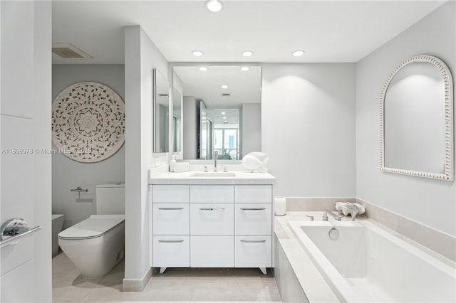 bathroom featuring a relaxing tiled tub, vanity, tile patterned flooring, and toilet