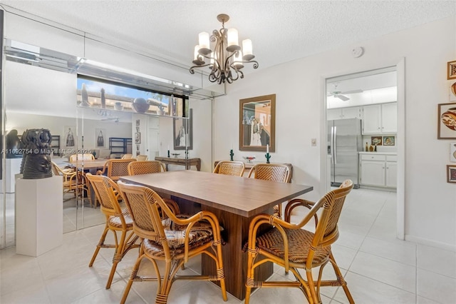 tiled dining area with ceiling fan with notable chandelier and a textured ceiling