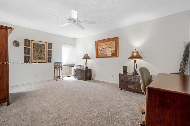 carpeted office featuring a textured ceiling and ceiling fan