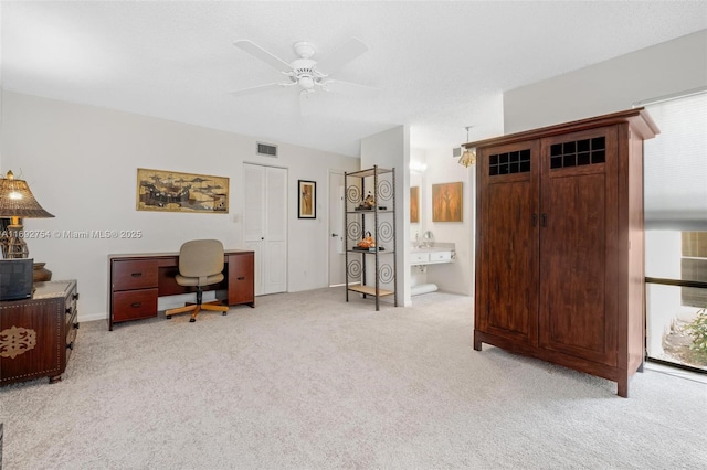 office space featuring light carpet and ceiling fan