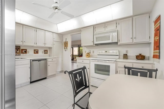 kitchen with ceiling fan, white cabinets, light tile patterned flooring, and white appliances