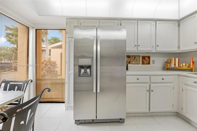 kitchen with white cabinetry, stainless steel fridge with ice dispenser, and light tile patterned floors