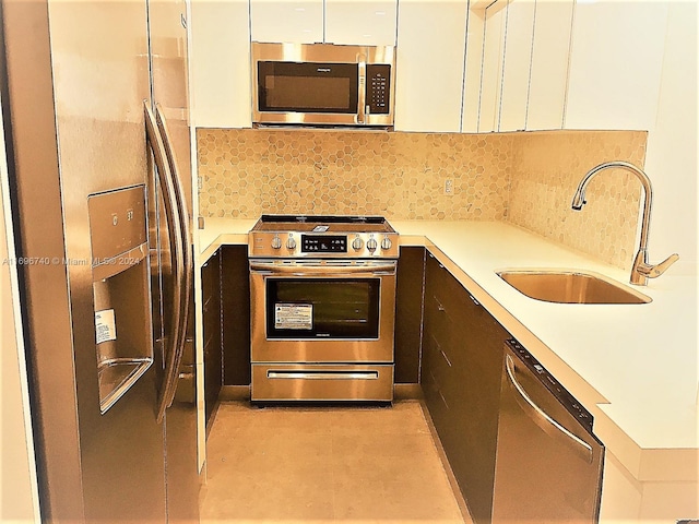 kitchen featuring decorative backsplash, white cabinetry, sink, and appliances with stainless steel finishes