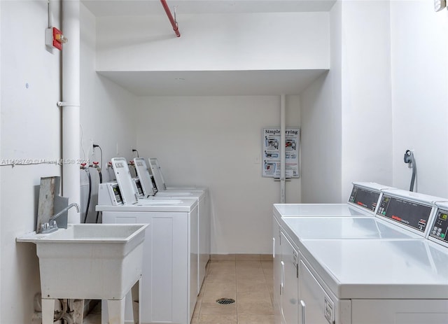 washroom featuring washer and clothes dryer, light tile patterned floors, and sink