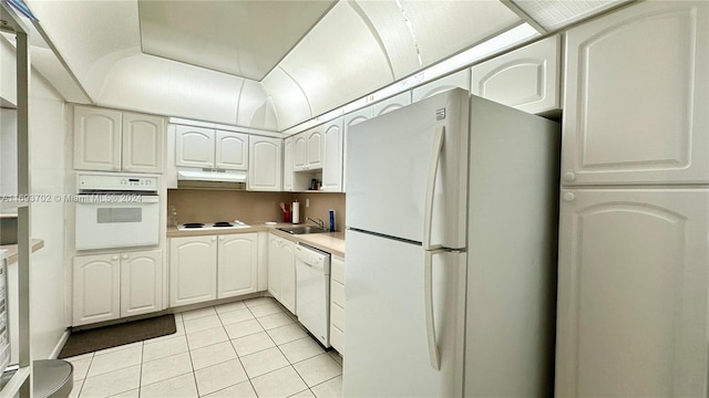 kitchen featuring white cabinets, light tile patterned floors, white appliances, and sink