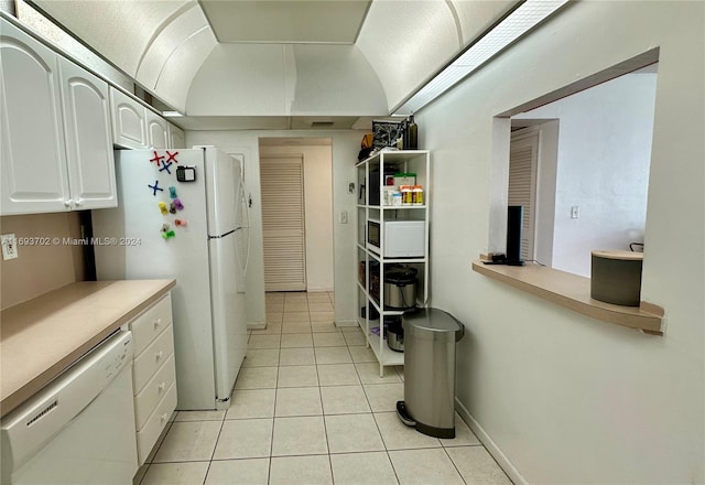 kitchen featuring white cabinetry, light tile patterned flooring, and white appliances