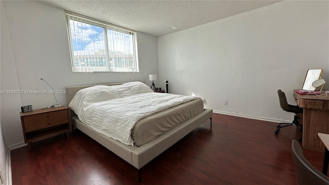 bedroom with a textured ceiling and dark hardwood / wood-style flooring