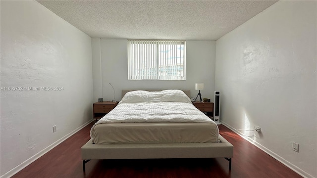 bedroom with dark hardwood / wood-style flooring and a textured ceiling