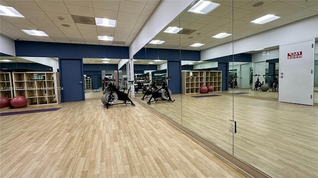 gym featuring hardwood / wood-style floors, a drop ceiling, and basketball court