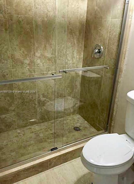 bathroom with an enclosed shower and toilet