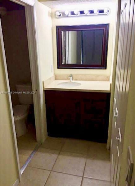 bathroom with tile patterned flooring, vanity, and toilet