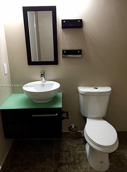 bathroom featuring tile patterned floors, vanity, and toilet