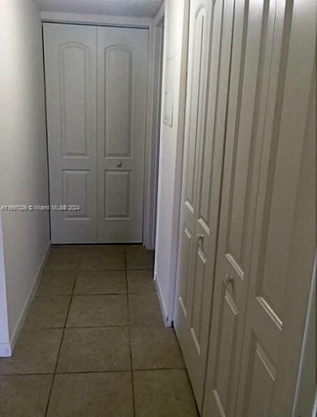 corridor with light tile patterned flooring