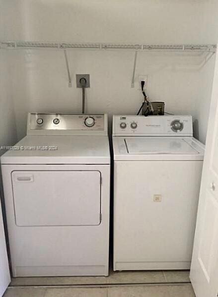 washroom with washing machine and dryer and light tile patterned floors