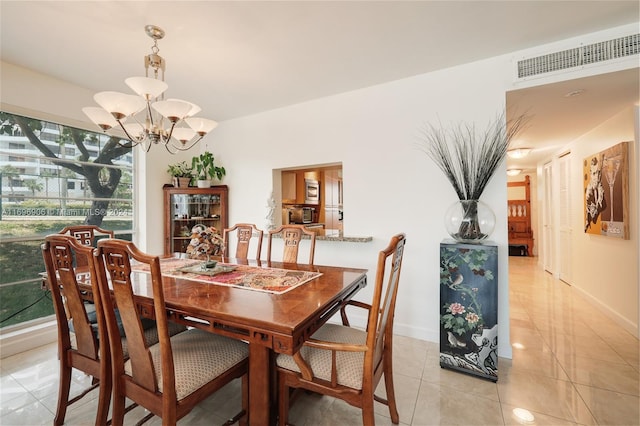 dining area with a notable chandelier and light tile patterned flooring